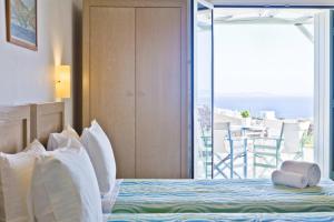 a bedroom with a bed with a view of the ocean at Niriides Homes & Villas in Elia Beach