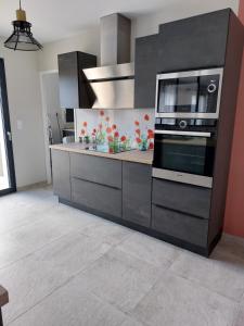 a kitchen with a stove and a microwave at le pavillon in Bonnat