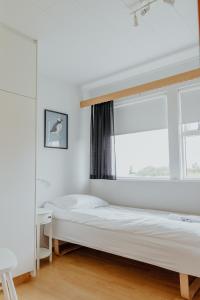 a bedroom with a bed and a window at Lambanes-Reykir Holiday Home in Barð