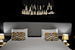 1 dormitorio con 1 cama con 2 almohadas y lámpara de araña en Location...Acropolis!, en Atenas