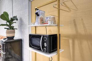 a microwave sitting on a shelf next to a tv at THe Oleander Hotel Room Number 4 in Galveston