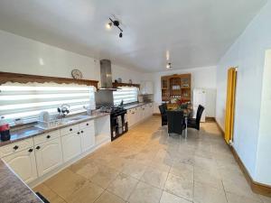 a large kitchen with white cabinets and a table at Park Terrace Professional Let in Bedlington