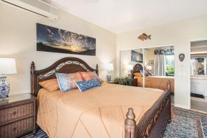 a bedroom with a large bed and a living room at Emmalani Court 312 condo in Princeville +13 photos