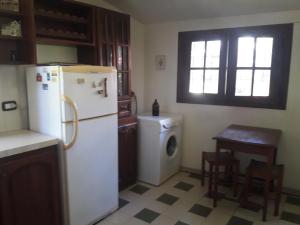 a kitchen with a refrigerator and a washing machine at Casa de campo La Brea in San Fernando del Valle de Catamarca