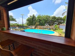 a window with a view of a swimming pool at Shikoa Sobole - Le Morpho et l'Ara in Montjoly