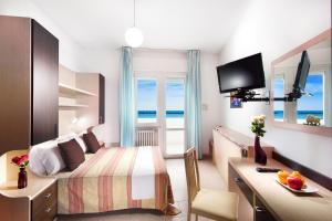 Hotel Asiago Beach في ليدو دي سافيو: غرفة فندقية مع سرير مطلة على المحيط
