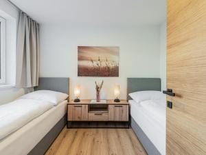 dwa łóżka w pokoju z dwoma świecami na stole w obiekcie Apartment Alpenherz w mieście Sautens