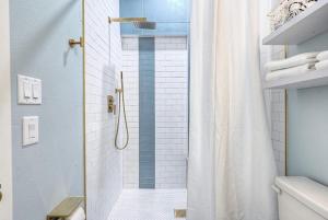 a bathroom with a shower with a shower curtain at The Oleander Hotel Room 5 in Galveston