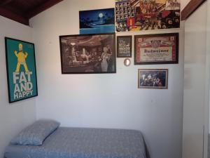 um quarto com uma cama e quadros na parede em Casa grande com piscina em Florianópolis em Florianópolis