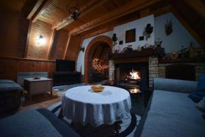 a living room with a table and a fireplace at Vila Jovanovic in Zlatibor
