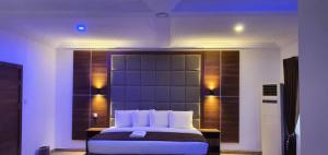 a bedroom with a large bed with lights on it at Presken Hotel (Reliance) in Ikeja