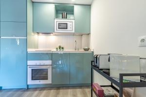 a kitchen with blue cabinets and white appliances at Divina Home Apartments in La Cala de Mijas