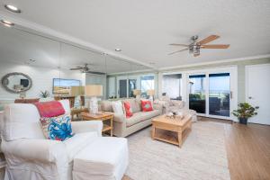 a living room with white furniture and a ceiling fan at Sunrise Villa in Ponte Vedra