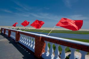a row of red flags on a brick fence at Mini-hotel Tikhaya Gavan in Kyrylivka