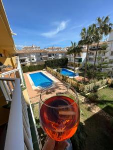 una persona sosteniendo una copa de vino en un balcón en Divina Home Apartments, en La Cala de Mijas