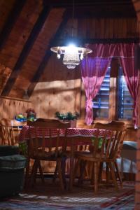 mesa de comedor con sillas y lámpara de araña en Vila Jovanovic, en Zlatibor