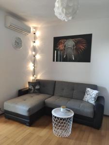 a living room with a couch and an elephant picture at Apartman Elephant in Postira