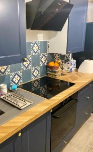 a kitchen with blue cabinets and a counter with fruit on it at BRICK Apartment in Žilina