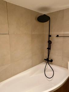 La salle de bains est pourvue d'une baignoire et d'une douche. dans l'établissement BRICK Apartment, à Žilina