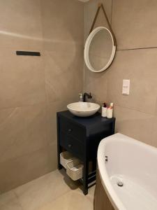 a bathroom with a sink and a mirror and a tub at BRICK Apartment in Žilina