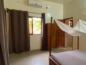 Schlafzimmer mit einem Bett und einem Fenster in der Unterkunft Résidences Ouadada in Porto-Novo