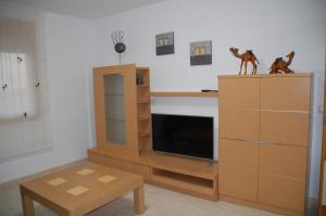 a living room with a entertainment center with a tv at PROALMAR, chalet 17 in Peniscola