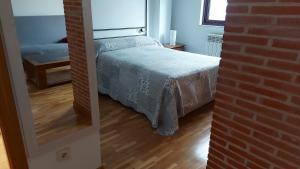 sypialnia z łóżkiem i ceglaną ścianą w obiekcie LOFT Estudio BRETON GRAN VIA w Salamance