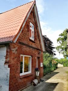 a brick house with a red roof and a window at Alte Schusterei direkt am Fluss und Altstadt in Oberndorf