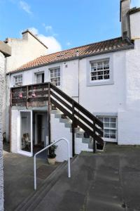 a house with a wooden staircase in front of it at Old fisherman's Cottage No 4, free parking in Edinburgh