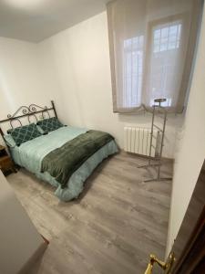 1 dormitorio con 1 cama con edredón verde y ventana en Precioso y confortable piso en el Casco Histórico, en Oviedo