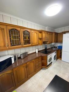 - une cuisine avec des placards en bois et un réfrigérateur blanc dans l'établissement Precioso y confortable piso en el Casco Histórico, à Oviedo