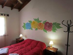 - une chambre ornée d'une peinture murale représentant des fleurs dans l'établissement Cabañas San Miguel, à Cortaderas