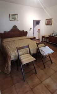 a bedroom with a large bed and two chairs at La Casa in Piazza in Gubbio
