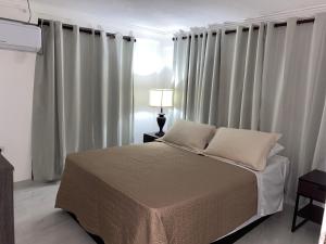 1 dormitorio con 1 cama grande y cortinas blancas en Posada Turistica el Swampito, en San Andrés