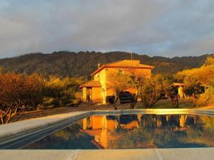 a house and a swimming pool in front of a house at Cabañas San Miguel in Cortaderas