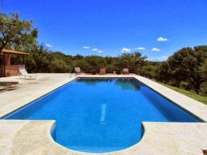 a large swimming pool with blue water in a yard at Cabañas San Miguel in Cortaderas