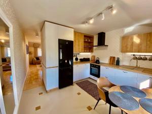 a kitchen with white cabinets and a black refrigerator at Apartamenty na Klasztornej in Jasło