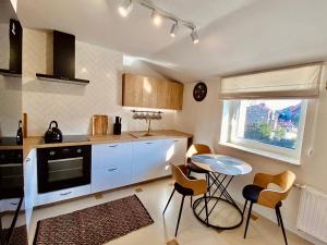 a kitchen with a table and chairs and a window at Apartamenty na Klasztornej in Jasło