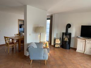 ein Wohnzimmer mit einem Tisch und einem Holzofen in der Unterkunft Ferienhaus Igel in Burg