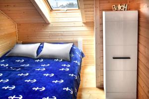 a bedroom in a tiny house with a bed and a window at Nadmorskie Klimaty - Domki Całoroczne in Stegna