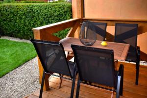 a wooden table with two chairs and a tennis ball on it at Nadmorskie Klimaty - Domki Całoroczne in Stegna