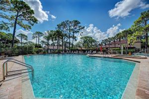 a large swimming pool at a resort with trees at Village des Pins 3645, 2 Bedrooms, Pool Access, WiFi, Hot Tub, Sleeps 4 in Sarasota