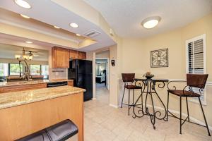a kitchen with a black refrigerator and a table at Village des Pins 3645, 2 Bedrooms, Pool Access, WiFi, Hot Tub, Sleeps 4 in Sarasota