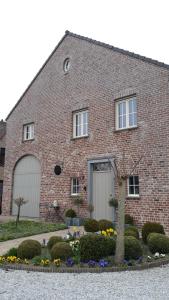 a brick building with two garage doors and flowers at B&B Valant in Bruges