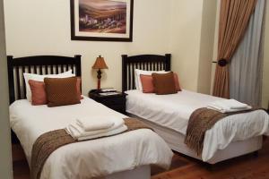 a bedroom with two beds with towels on them at Lali's Guest House in Harrismith