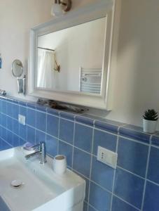 ein Bad mit einem Waschbecken und einem Spiegel in der Unterkunft La Casa di Nemo in Piombino