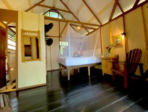 une chambre avec une table blanche dans une tente dans l'établissement Little Corn Island Beach and Bungalow, à Little Corn Island