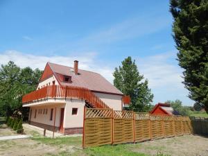 a house with a wooden fence in front of it at Napsugár Apartman in Baja
