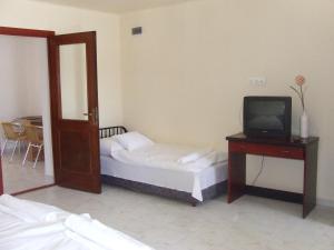 a small bedroom with a bed and a television at Napsugár Apartman in Baja