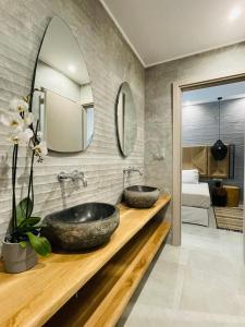 a bathroom with two sinks and a mirror at Soho Exclusive Suites in Skala Potamias